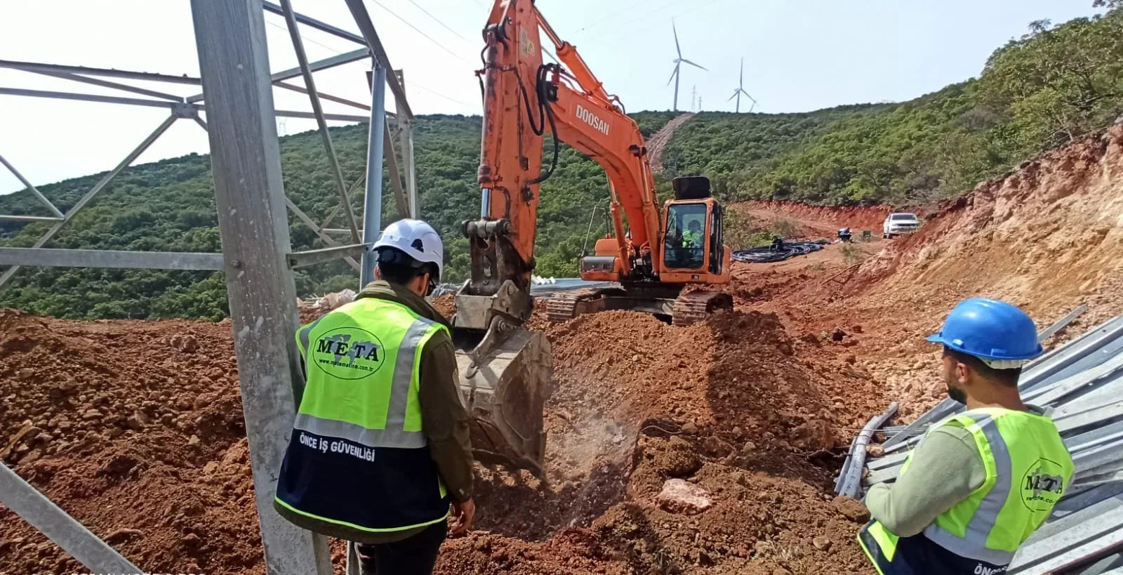 Susurluk RES enerji nakil hattı sahası — arka planda rüzgâr türbinleri, önde kazı çalışması