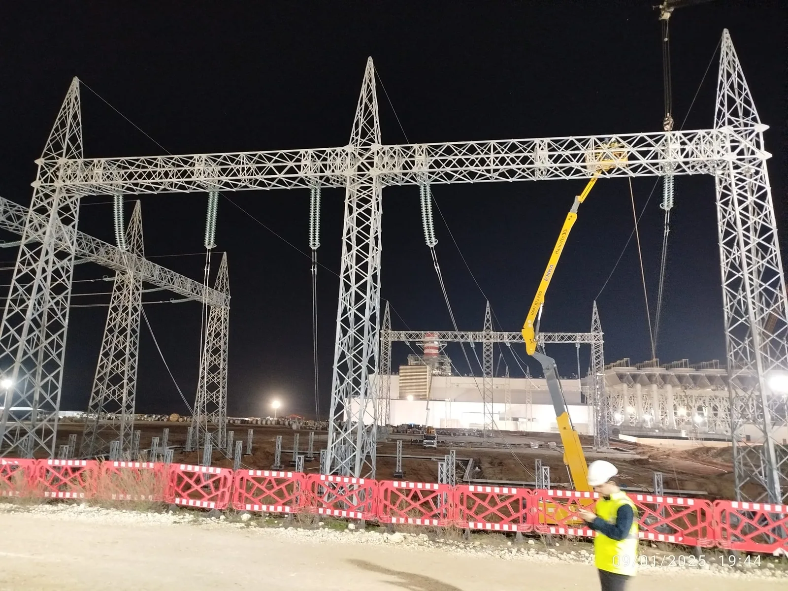 Gece vardiyasında aydınlatılmış şalt portalları ve vinçli çalışma